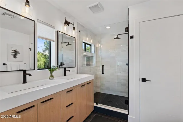 a bathroom with double vanity sink and mirror
