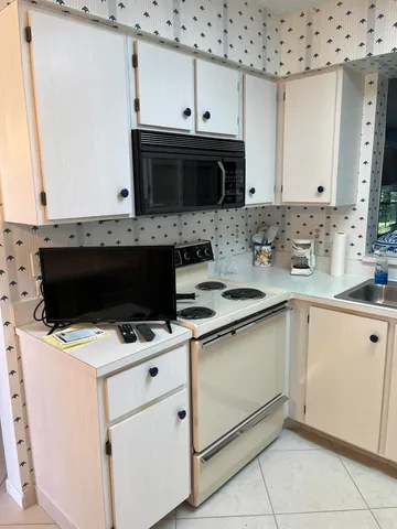 a kitchen with granite countertop a sink stove and microwave