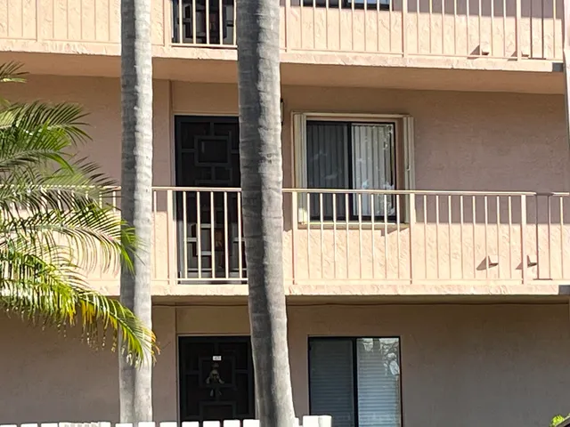 a view of a balcony with a plants and wooden fence