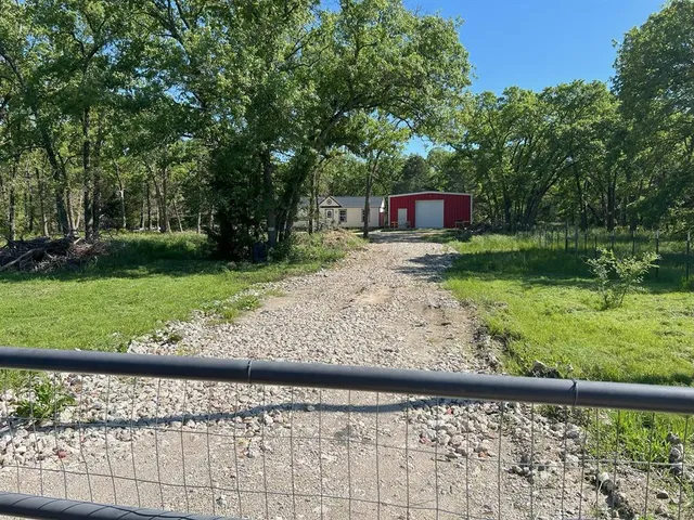 a view of a yard with a bench and trees