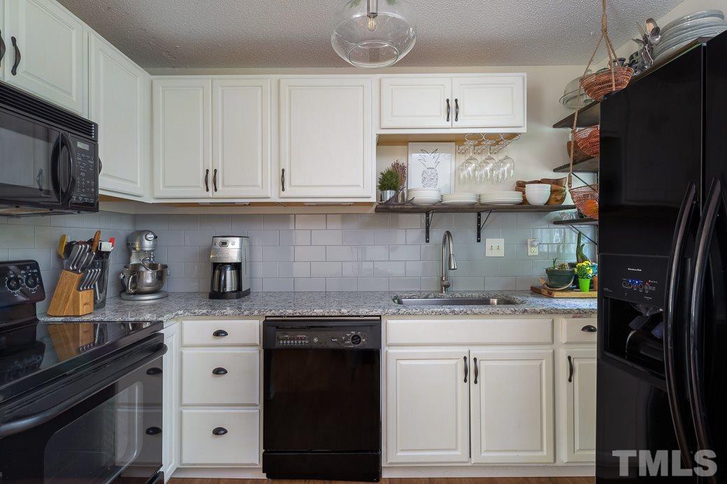 7625 Mine Valley Road Raleigh, NC 27615 - Photo 5 of 10 The open Kitchen offers GRANITE counter tops, a large deep sink, tiled back splash, WHITE CABINETRY, a breakfast nook & NEW flooring. COOL FLOATING SHELVES allow light to still pour in and offer additional storage!