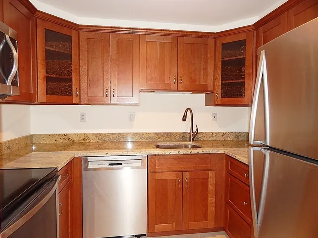 a kitchen with stainless steel appliances granite countertop a refrigerator and a sink