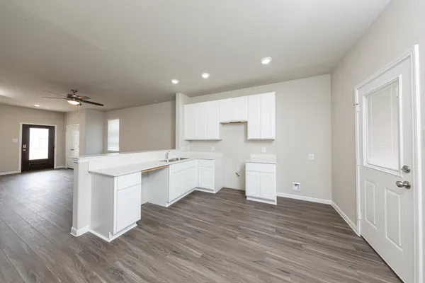 a kitchen with a sink and wooden floor