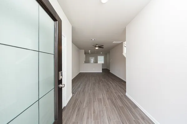 a view of a hallway with wooden floor