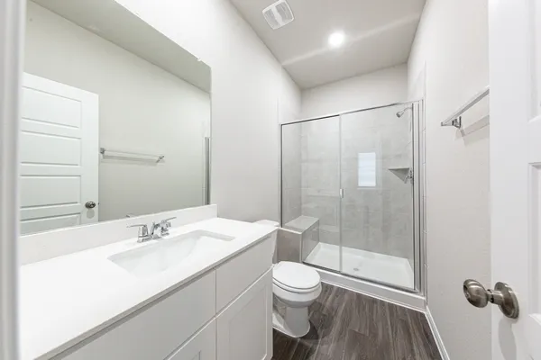 a bathroom with a sink a toilet and shower