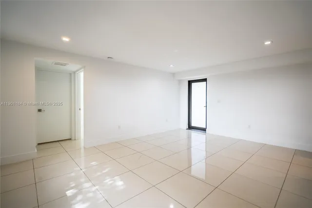 an empty room with white walls and tiles