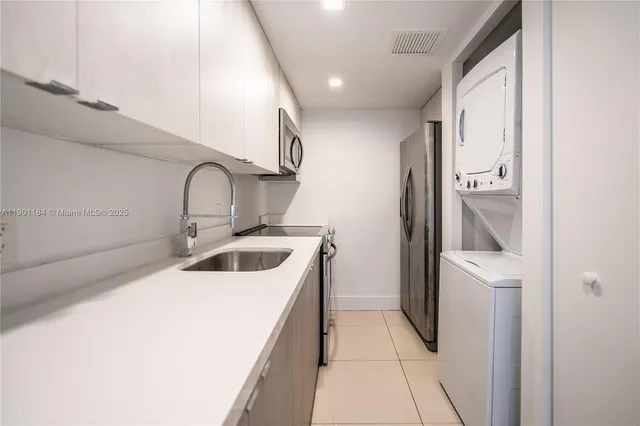 a kitchen with a sink a refrigerator and cabinets