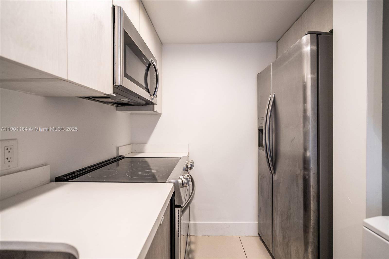 1985 Bay Drive, Unit 111 Miami Beach, FL 33141 - Photo 8 of 20 a kitchen with a refrigerator and a stove