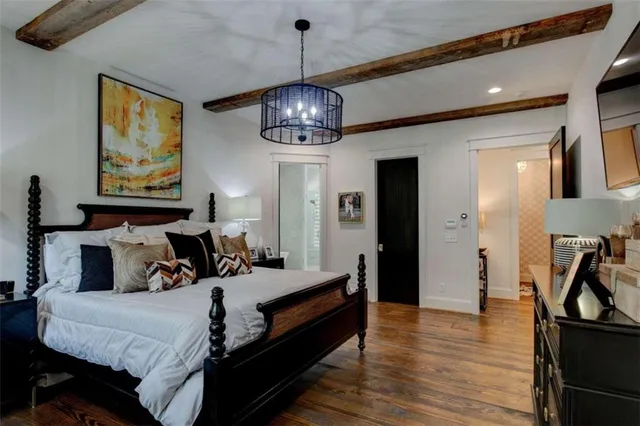 front view of a brick house with a lawn chairs and potted plants