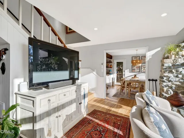 a kitchen with stainless steel appliances granite countertop a stove top oven a sink a dining table and chairs with white cabinets