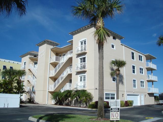 front view of a building with a palm tree