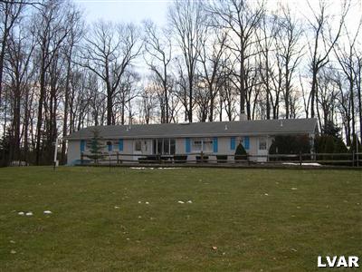 4017 Blacksmith Road New Tripoli, PA 18066 - Photo 2 of 12 BACK VIEW OF HOUSE IN TREE-LINED SETTING.
