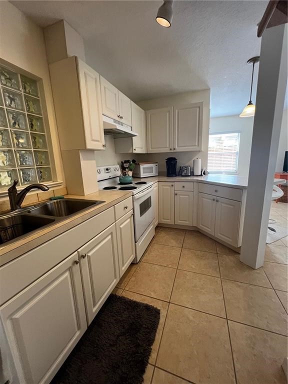 11195 Roseland Road, Unit 4 Sebastian, FL 32958 - Photo 5 of 10 a kitchen with a sink a stove top oven and white cabinets