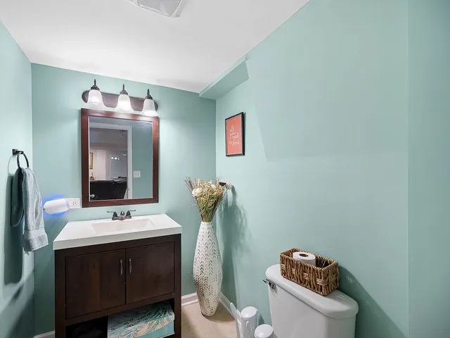 a bathroom with a sink mirror and toilet