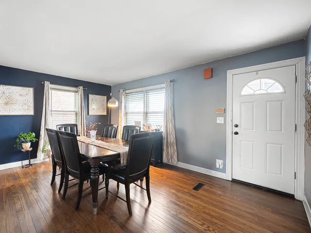 a view of a a dining room with furniture window and wooden floor