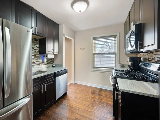 a kitchen with granite countertop stainless steel appliances a sink stove and refrigerator
