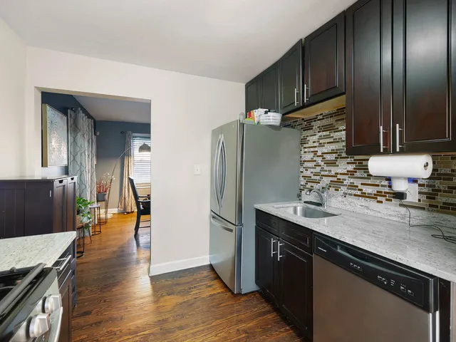 a kitchen with stainless steel appliances granite countertop a refrigerator a stove and a sink