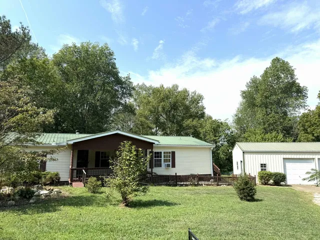 a view of a yard in front of a house with large tree