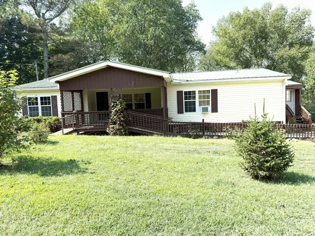 a front view of house with yard and trees around