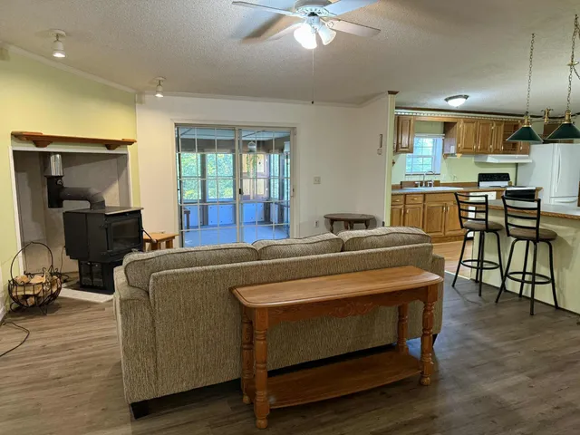 a living room with a couch and a dining table with wooden floor