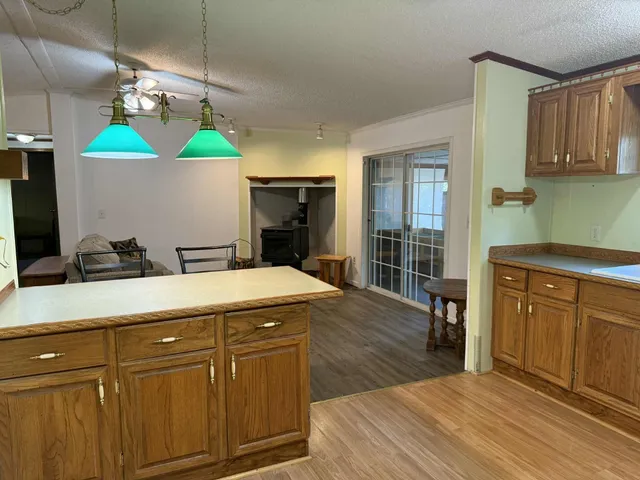a kitchen with kitchen island granite countertop a sink cabinets and wooden floor