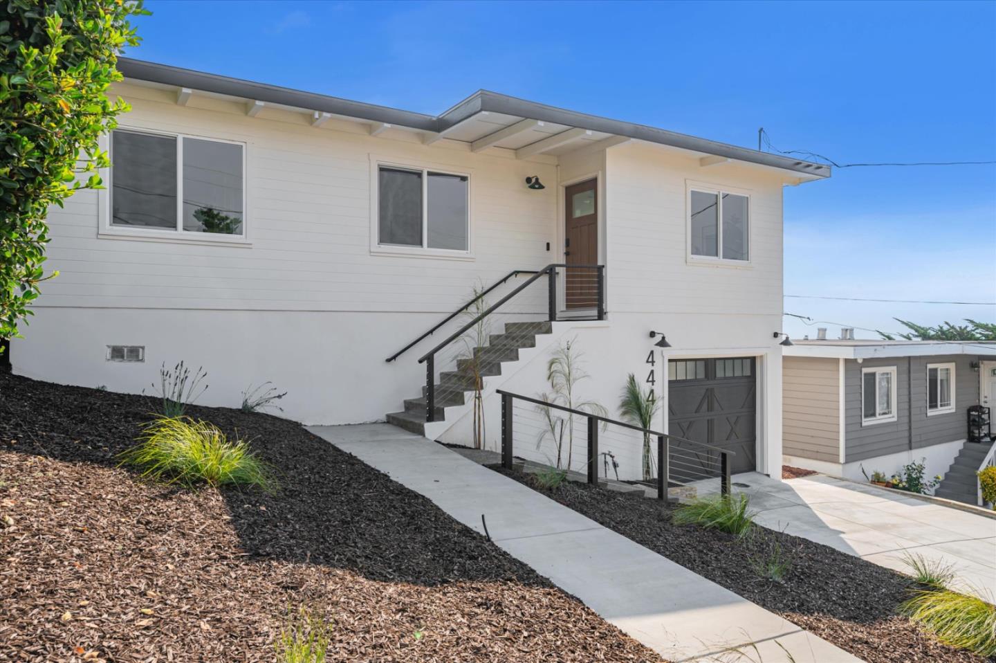 444 Manor Drive Pacifica, CA 94044 - Photo 44 of 70 a view of a white house with a small yard and wooden floor and fence