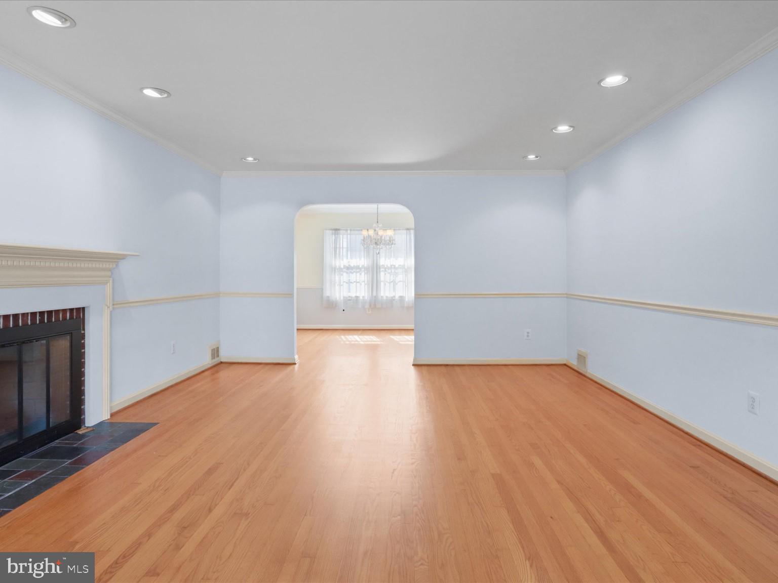 1002 Beverley Drive Alexandria, VA 22302 - Photo 7 of 46 an empty room with wooden floor and fireplace
