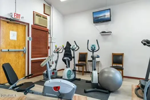 a living room with furniture a flat screen tv and gym equipment