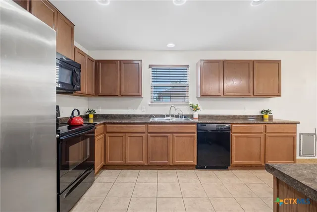 a kitchen with stainless steel appliances granite countertop a sink and stove top oven
