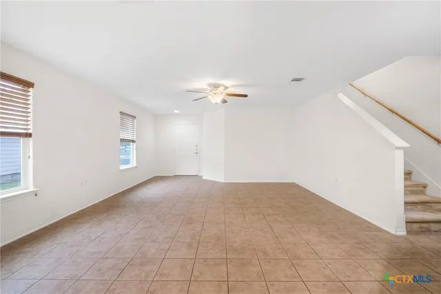 a view of a livingroom with a ceiling fan and window