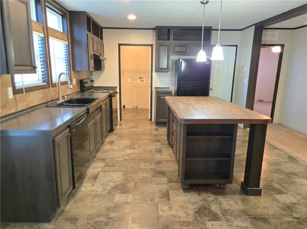 a kitchen with stainless steel appliances granite countertop furniture a refrigerator and a sink