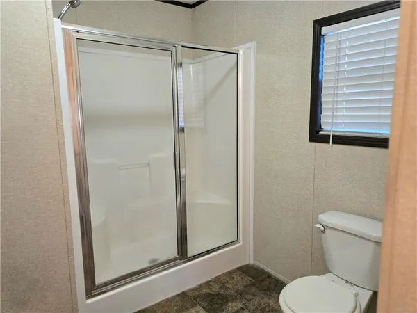 a bathroom with a toilet and a shower