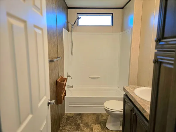 a bathroom with a granite countertop toilet and a shower