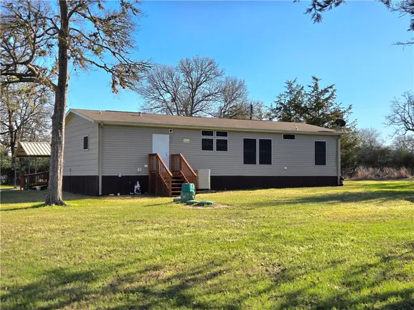 a view of a house with swimming pool and a yard