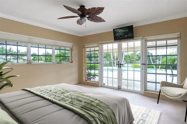 a bedroom with a large bed and a flat tv screen next to a window