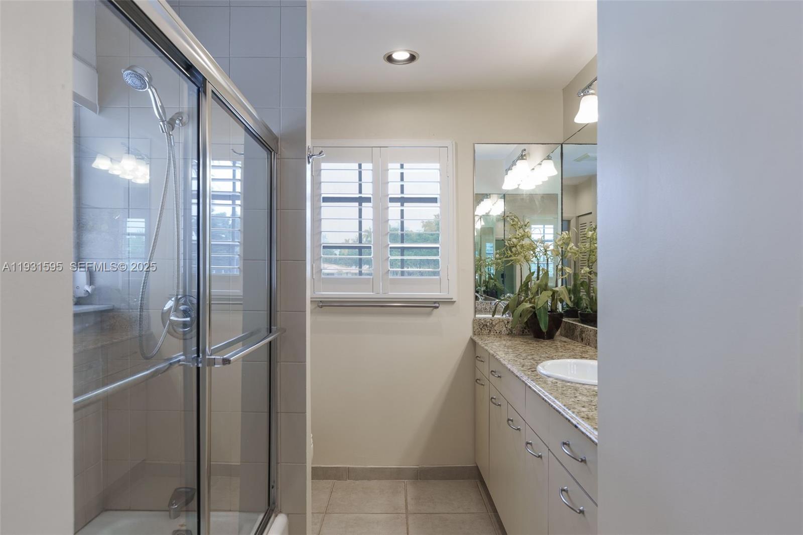 2130 Northeast 15th Street Fort Lauderdale, FL 33304 - Photo 26 of 32 a bathroom with a granite countertop sink mirror and shower