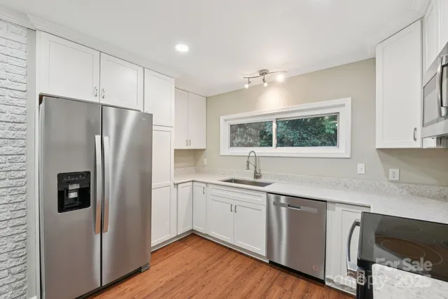 a kitchen with a refrigerator a sink and cabinets