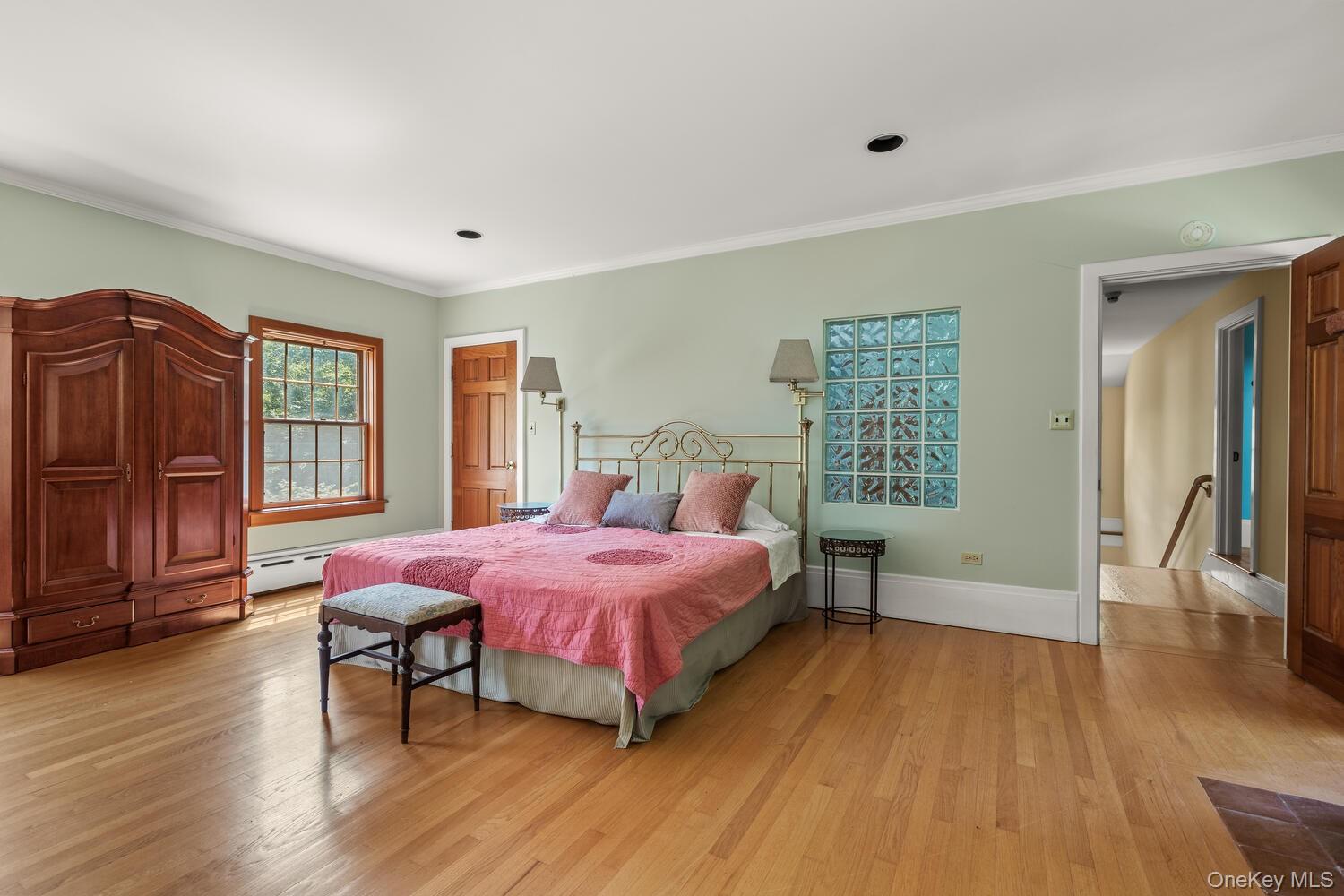 81 Glendale Road Ossining, NY 10562 - Photo 24 of 37 Bedroom featuring light wood-style floors, crown molding, and a baseboard radiator