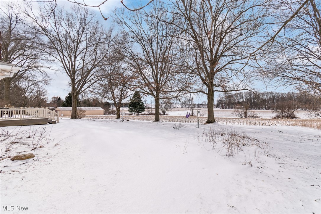 5208 Canaan Center Road Wooster, OH 44691 - Photo 29 of 33 Yard layered in snow with a wooden deck
