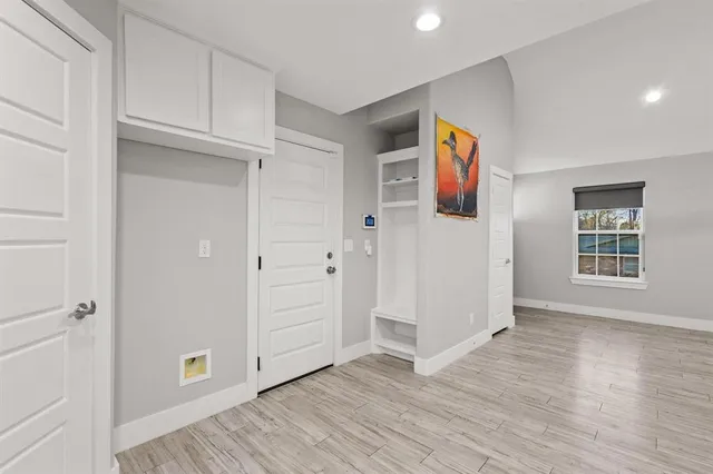 an empty room with wooden floor and window