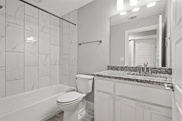 a bathroom with a sink toilet vanity and shower