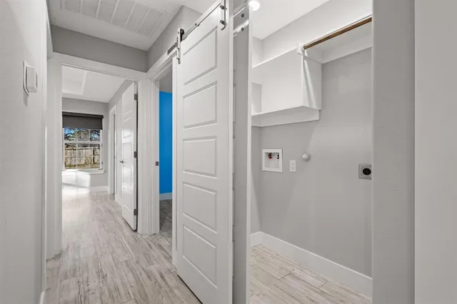 a view of a hallway with wooden floor and closet