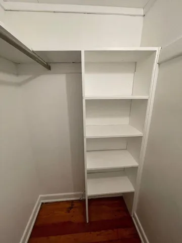 a view of walk in closet with empty racks
