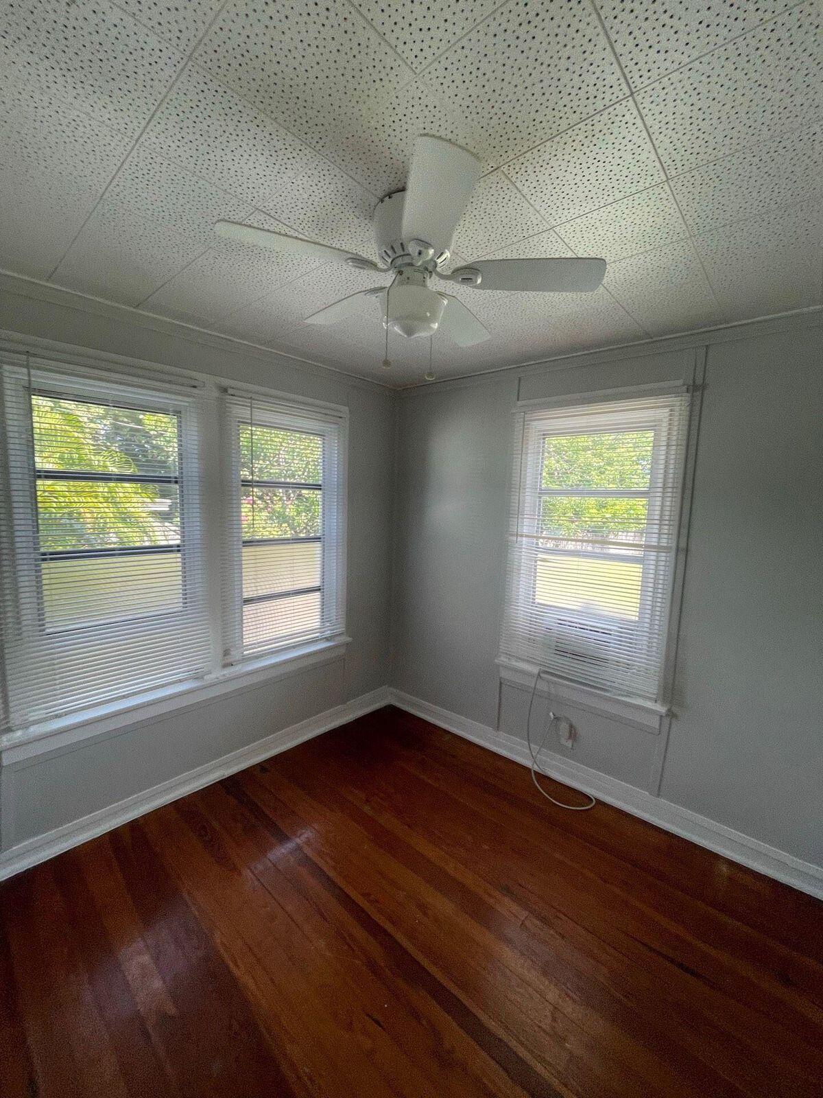 736 Omar Road, Unit 1 West Palm Beach, FL 33405 - Photo 17 of 25 a view of an empty room with wooden floor and a window