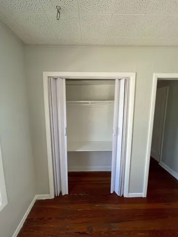 a view of walk in closet with wooden floor