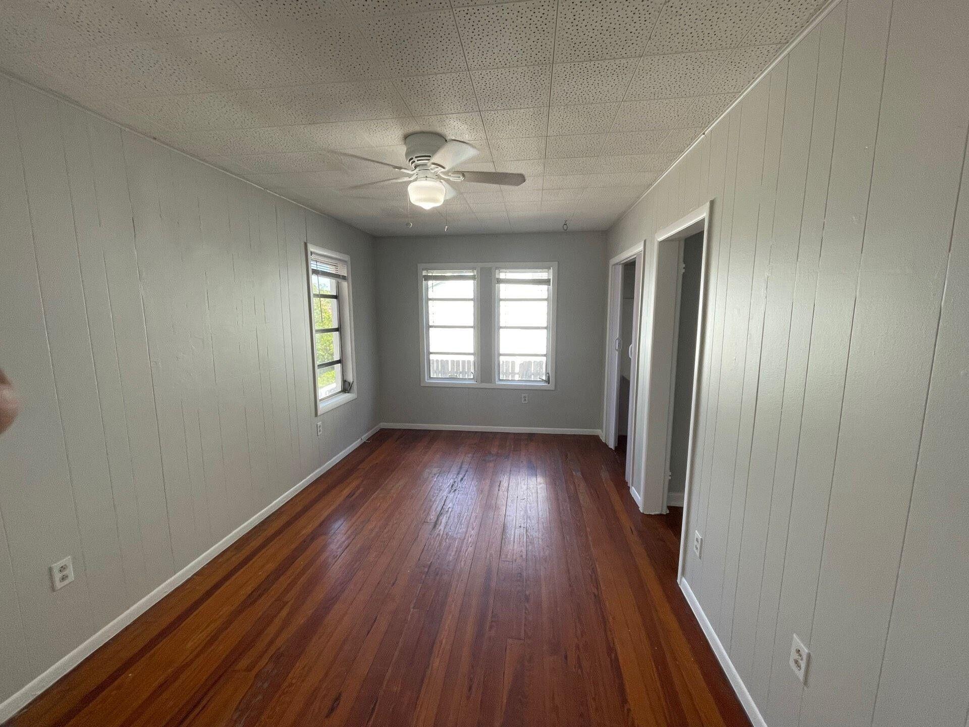 736 Omar Road, Unit 1 West Palm Beach, FL 33405 - Photo 24 of 25 an empty room with wooden floor and windows