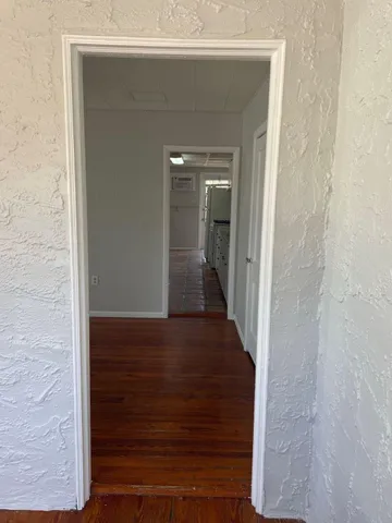 a view of a hallway with wooden floor