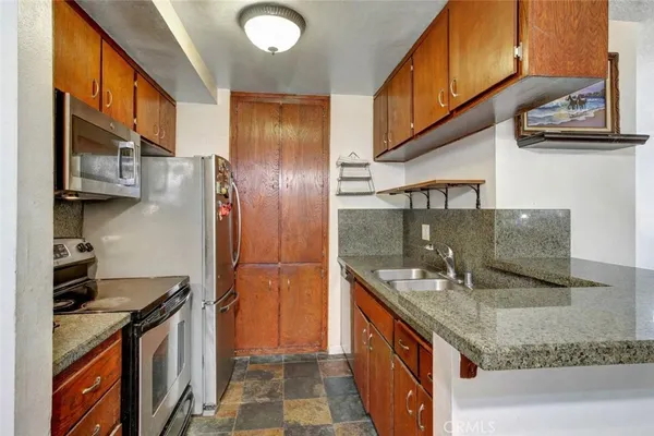 a kitchen with stainless steel appliances granite countertop a sink and a stove