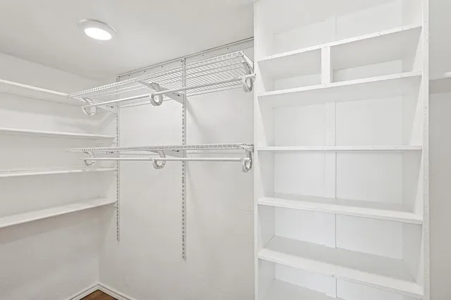 a view of walk in closet with empty racks