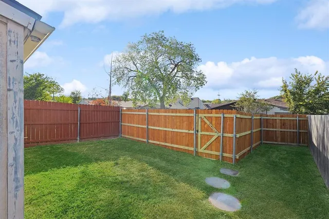 a view of a backyard with wooden fence